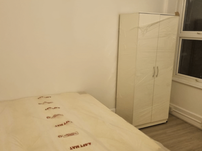 Comfortable double bedroom with essential furniture, heating, and Wi-Fi, perfect for long stays.