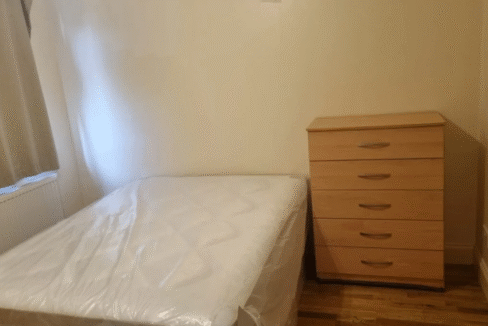 Comfortable double bedroom with essential furniture, heating, and Wi-Fi, perfect for long stays.