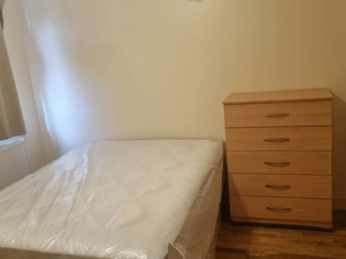 Comfortable double bedroom with essential furniture, heating, and Wi-Fi, perfect for long stays.